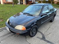 Front three-quarter view showing black exterior, left headlight, steel wheel
