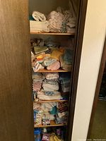 Full view of wooden shelving closet filled with stacked folded linens and towels.