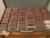 Full metal case open showing approx 120 photo slides neatly arranged in rows