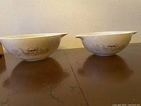 Full view of both Pyrex mixing bowls side by side showing beige speckled background and brown mushroom pattern