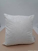Front side of the off-white/cream square waterfowl feather pillow showing the puffed fabric exterior