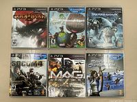 Photo showing all six PlayStation 3 game cases front covers: God of War III, LittleBigPlanet 2, Starhawk, SOCOM 4, MAG, Sports Champions.