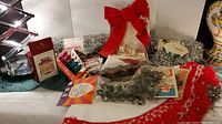 Overview of assorted Christmas decorations including light bulbs, garland, a large red bow, stockings, and more.