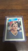 Photo of Brett Hull rookie card in a protective plastic case on a wooden surface.