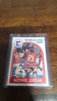 Photo of Michael Jordan 1989 NBA All-Star Game basketball trading card in protective plastic case on wooden surface