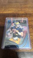 Photo of a Tom Brady football trading card from the Select series featuring him in a Pittsburgh Steelers uniform, enclosed in a clear plastic protective case.