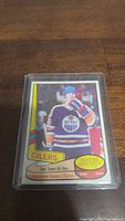 Photo of a 1980-81 Wayne Gretzky hockey card featuring Edmonton Oilers and 2nd Team All-Star designation, protected in a plastic sleeve.