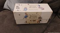 Closed decorative collector's box labeled 'The World of Peter Rabbit by Beatrix Potter' with character illustrations on the box. The box shows slight wear.
