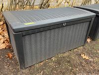 Side view of the Keter plastic storage bin showing woven rattan style texture and lockable lid