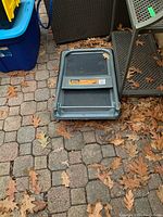 Image showing the folded platform cart lying on a brick pavement with dry leaves around it.