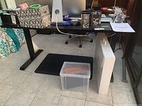 Front view of desk showing full top and legs with miscellaneous items on surface