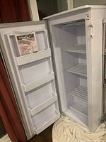 Interior view showing door open, three plastic door bins and manual in top bin