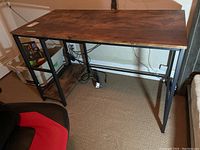 Front side view of wood table with metal legs and shelf on left side showing overall structure and condition.