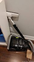 Side view of black Electrolux Jetmaxx EL4040 vacuum cleaner showing hose attached and upright wand with brush head.