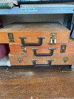 Two stacked wooden art supply cases with metal clasps and black handles
