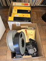 Two cardboard boxes: front holds Nikon F3 HP SLR with motor drive and 35mm slide trays; rear holds Kodak slide trays