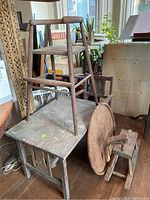 High chair on small wooden table with woven tabletop leaning and hobby horse nearby