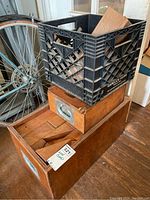 Two wooden boxes stacked with wood blocks visible inside. One box has metal handle and label slot; the other has red markings on the lid.