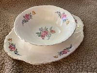 Two-piece vintage Ironstone serving set with serving bowl stacked on platter showing Hazel floral pattern and gold trim.