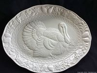Full view of the oval white ceramic turkey platter with embossed turkey and floral border.