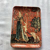 Top-down image of rectangular melamine dish with renaissance themed image of a lady and unicorn on floral background