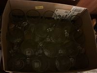 Photo showing multiple clear glass bar mugs inside a cardboard box. Approximately 21 plain mugs visible from top view.