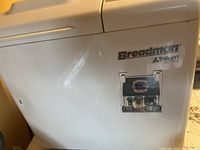 Side view showing Breadman and Trillium branding, older style bread maker with wear marks.