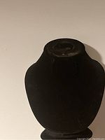 Single black velvet necklace display bust photographed against white background.