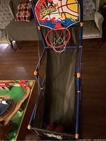 Full view of toddler freestanding basketball court with storage net and balls