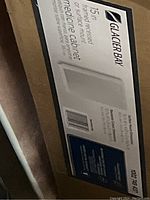 Photo of the original box showing Glacier Bay branding, product specifications, and image of the medicine cabinet.