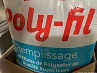 Close-up image of the front of a Poly-Fil polyester fiberfill bag showing branding and product details in French.