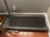 Close view of Weslo treadmill running belt and frame on a wooden floor