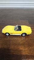 Side view of yellow 1969 Corvette Stingray model car with visible hood and wheel details
