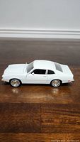 Side view of the white 1/24 scale 1974 Ford Maverick diecast model car showing the smooth body lines and whitewall tires.