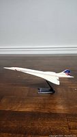 Front-right angle view of the British Airways Concorde model airplane on its black stand, showing the sharp nose and wing details.