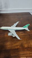 Side view of Saudia Boeing 747-300 plastic airplane model on a wooden surface.