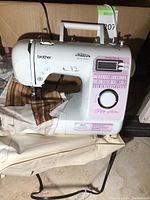 Brother Innov-is 40e Project Runway Edition sewing machine on beige fabric with some sewing in progress.