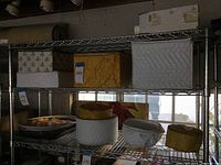 Wire shelving holding multiple padded boxes containing china pieces