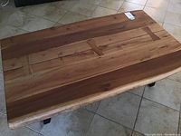 Top view of thick solid wood coffee table top with bowtie inlay detail and natural wood tones.