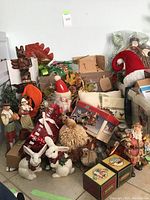 Full view of assorted holiday decor including wreaths, figurines, nutcracker, and small statues piled together.
