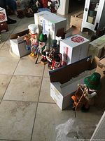 Lineup of several wooden nutcrackers including baker, hunter, toymaker, guard, some in boxes