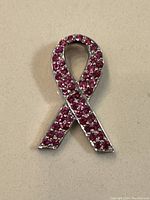 Front view of pink ribbon pendant showing front with pink stones.