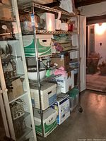 Metal wire storage rack shelving unit filled with various household storage boxes and containers.