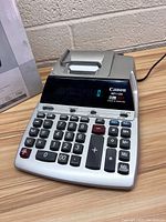 Canon MP11DX desktop calculator front view with buttons and display visible.