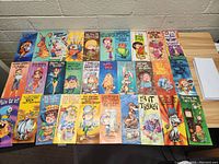 Full view of all 30 vintage birthday cards arranged in rows on a wooden surface along with accompanying white envelopes to the right.