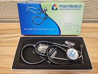 Top view of the black Prism Medical PM-2 Elite Dual Head Stethoscope in its original box with accessories.