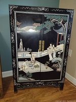 Full front view of cabinet showing painted Chinese garden scene and brass hardware