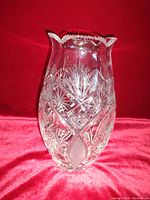 Front view of heavy lead crystal vase showing detailed cut patterns and scalloped lip with chip.