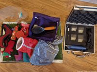Overall view of dog grooming and care items including coats, brush, leash, plastic tray with fake grass, dog toys, and grooming case.