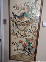 Full view of the framed silk painting with detailed birds and natural scenery.
